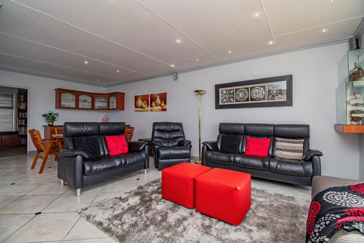 Spacious living room featuring tiled flooring, recessed downlighting, and built-in wall cabinetry, offering a comfortable and functional layout.