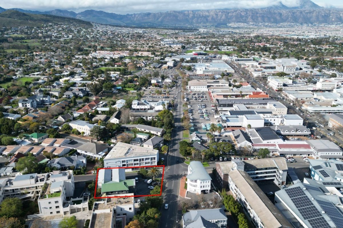 Aerial view of the office property highlighting its location within the commercial district, featuring on-site parking and proximity to local amenities.