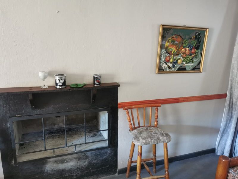 A living room area featuring a built-in fireplace with a wooden mantelpiece and decorative chair rail molding along the wall.