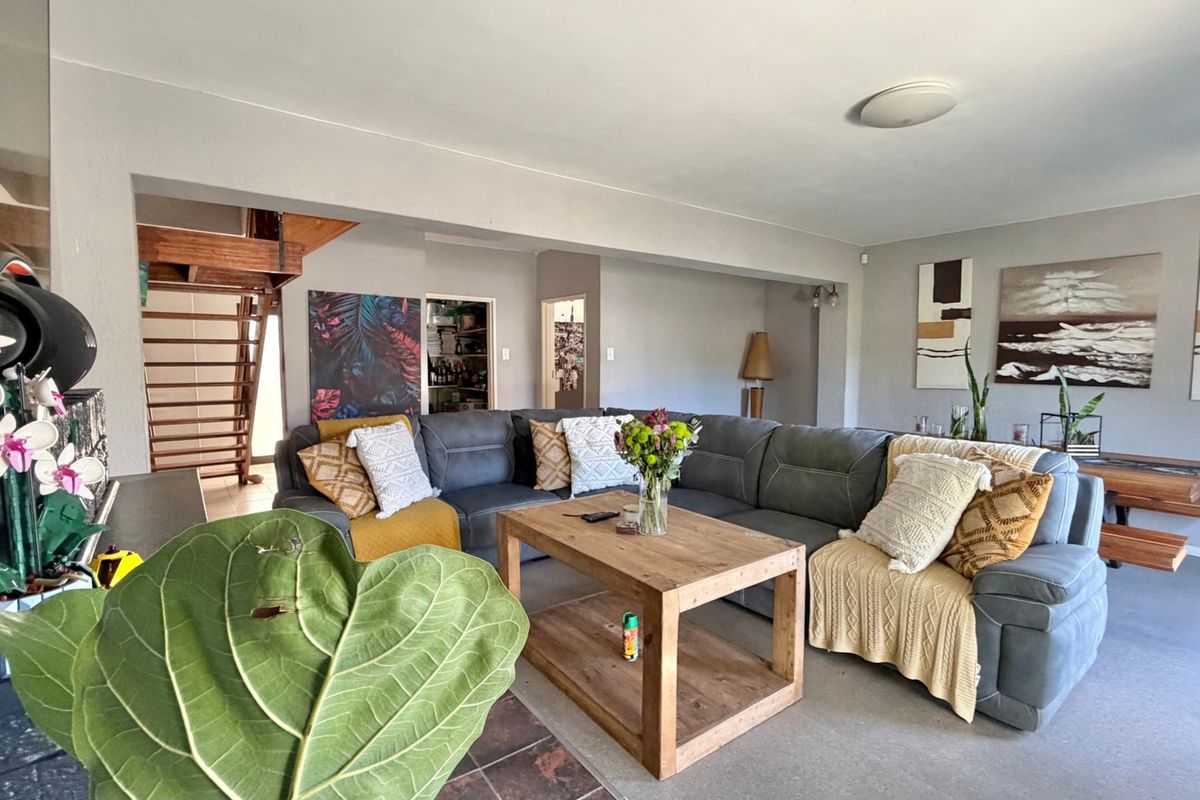 Spacious living room featuring a wooden staircase, tiled hearth, and neutral wall finishes, offering a comfortable and functional layout for relaxation.