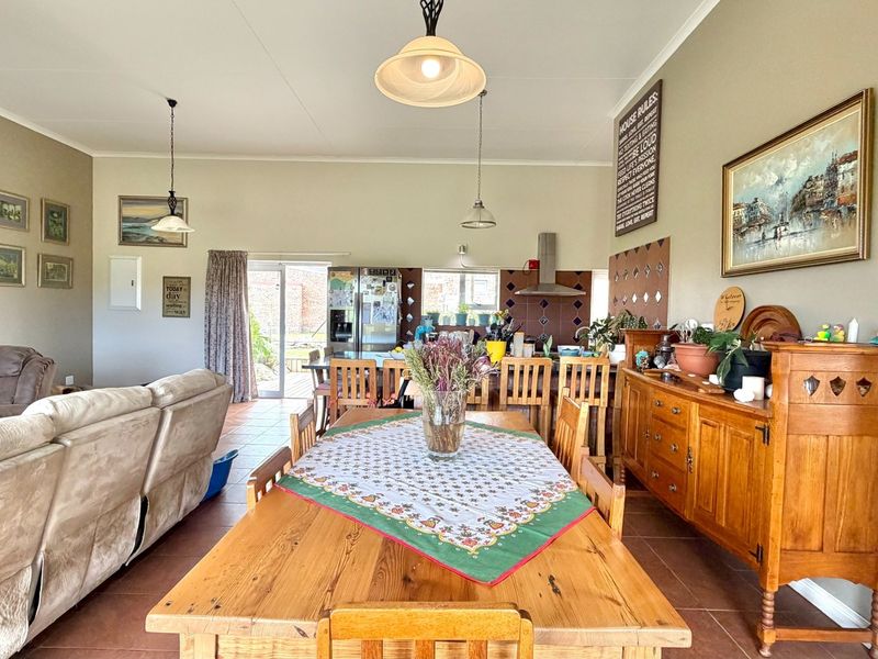 Spacious open-plan living and dining area featuring tiled floors, pendant lighting, and direct access to the rear exterior through sliding glass doors.