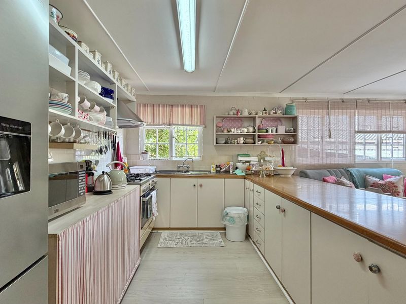 Open plan kitchen featuring built-in cabinetry, laminate countertops, and a gas hob, seamlessly flowing into the adjacent living area.