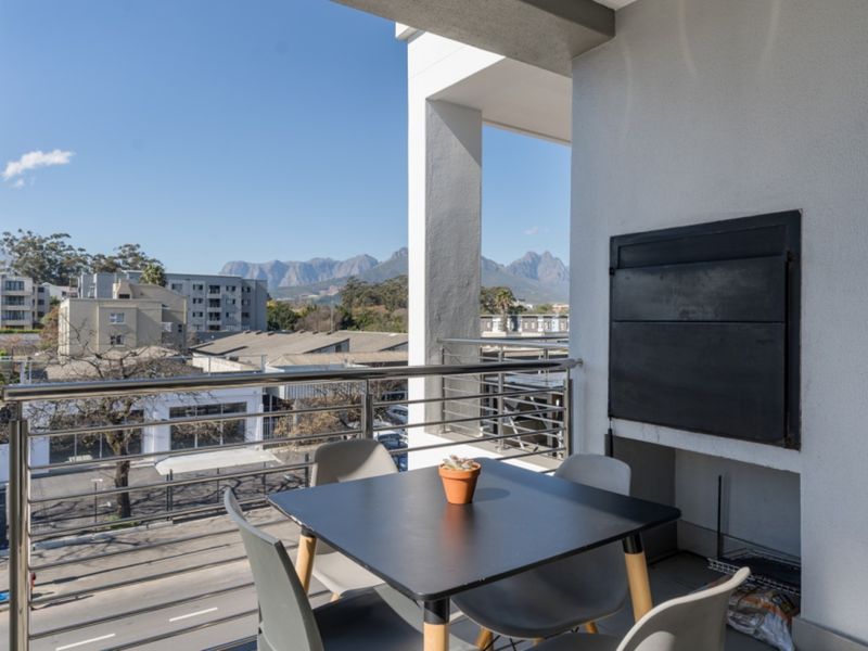 Covered balcony featuring a built-in braai, stainless steel balustrade, and scenic mountain views.