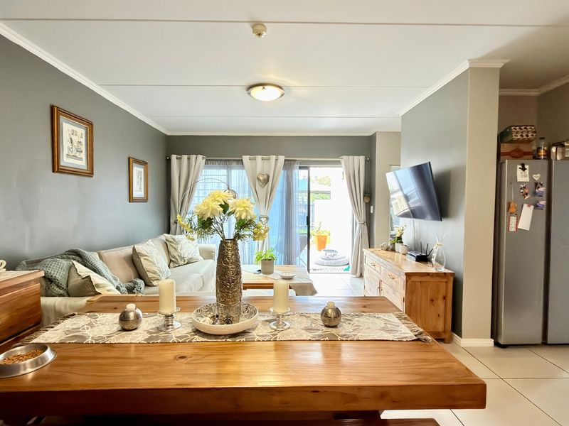 Open-plan living and dining area featuring tiled flooring and a sliding glass door providing access to the outdoor space.