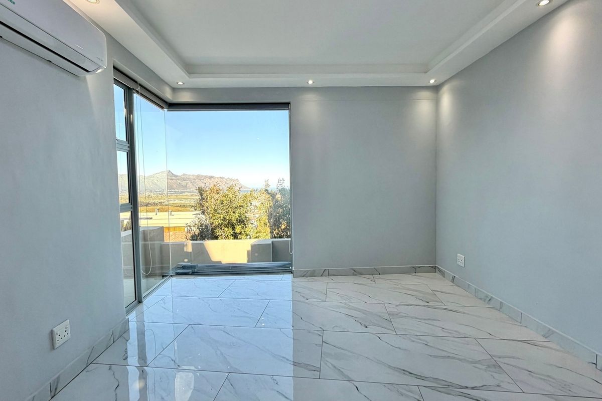 A bright, empty bedroom featuring modern marble-look floor tiles, recessed ceiling lighting, an air conditioning unit, and a large corner window with scenic views.