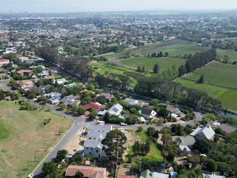 An aerial view of a residential neighborhood featuring paved streets, established homes, and surrounding green spaces.