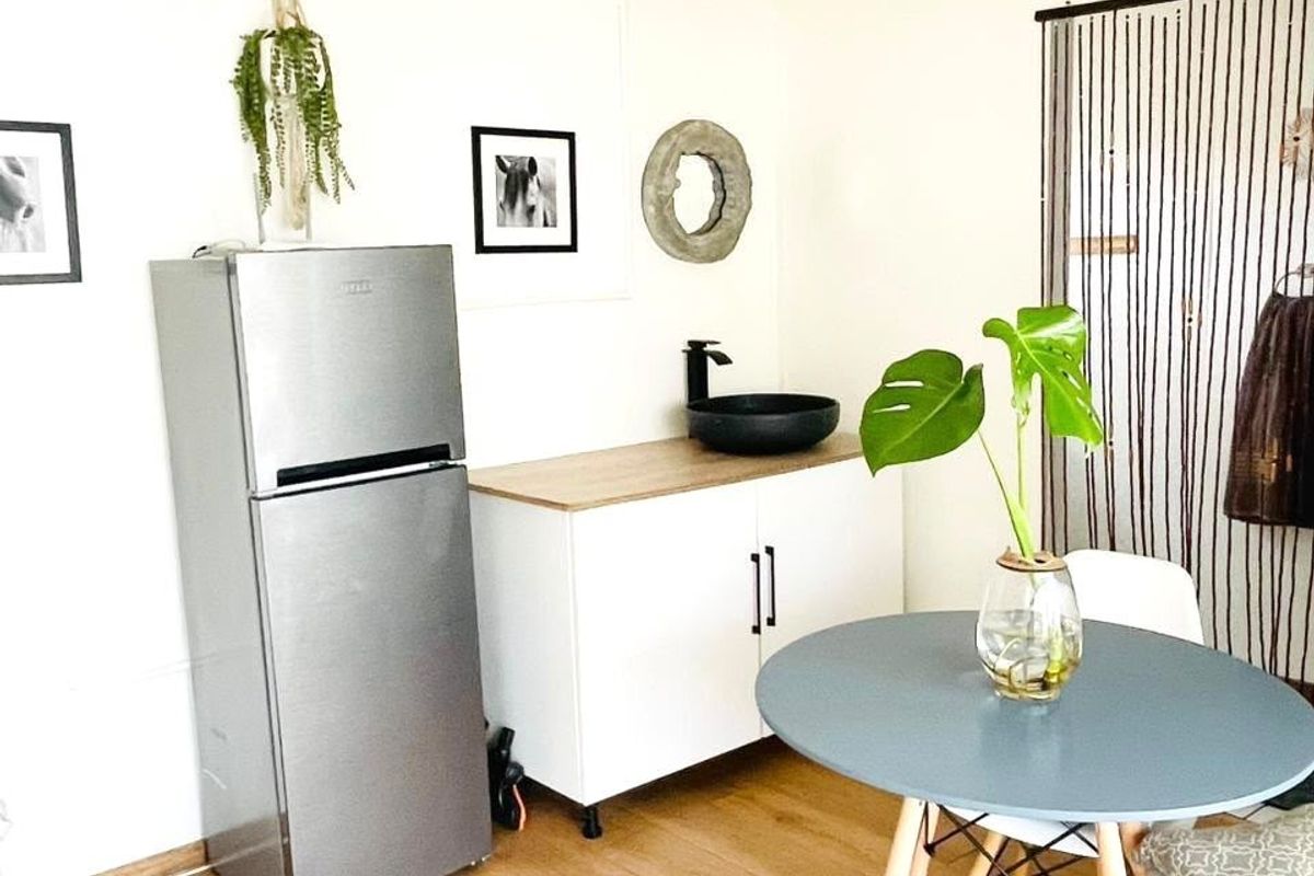 A compact kitchenette area featuring a modern vessel sink, vanity cabinet, and wood-look laminate flooring, suitable for a small farm studio or guest unit.