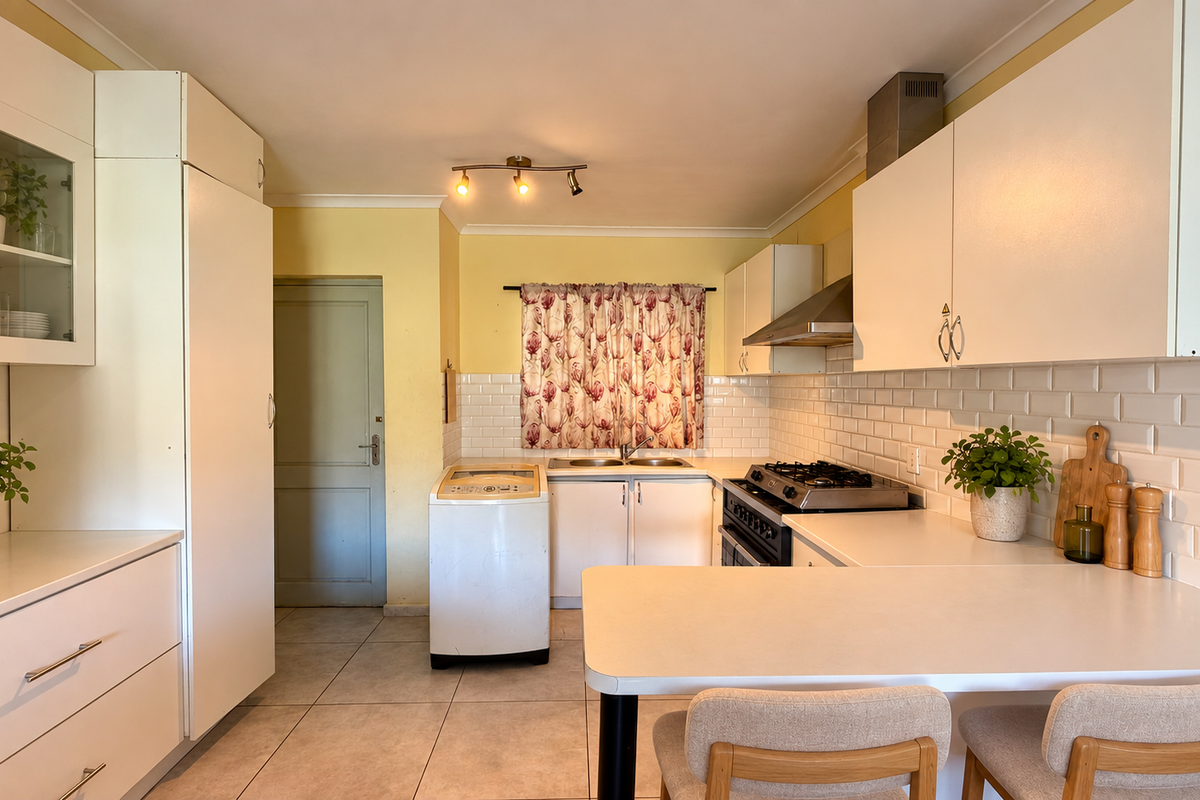 A functional kitchen featuring white cabinetry, a subway tile backsplash, gas hob with extractor, and a convenient breakfast counter for casual dining.