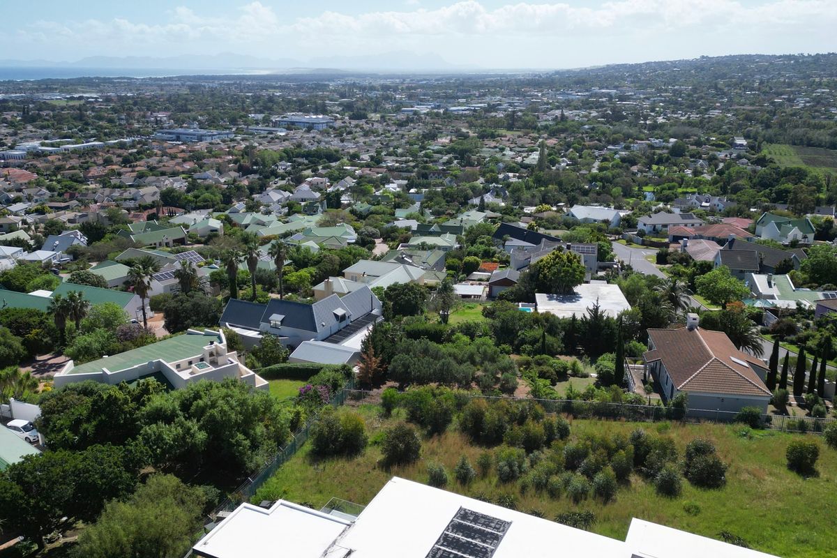 An aerial view of a residential neighborhood showing surrounding properties, mature trees, and established landscaping.