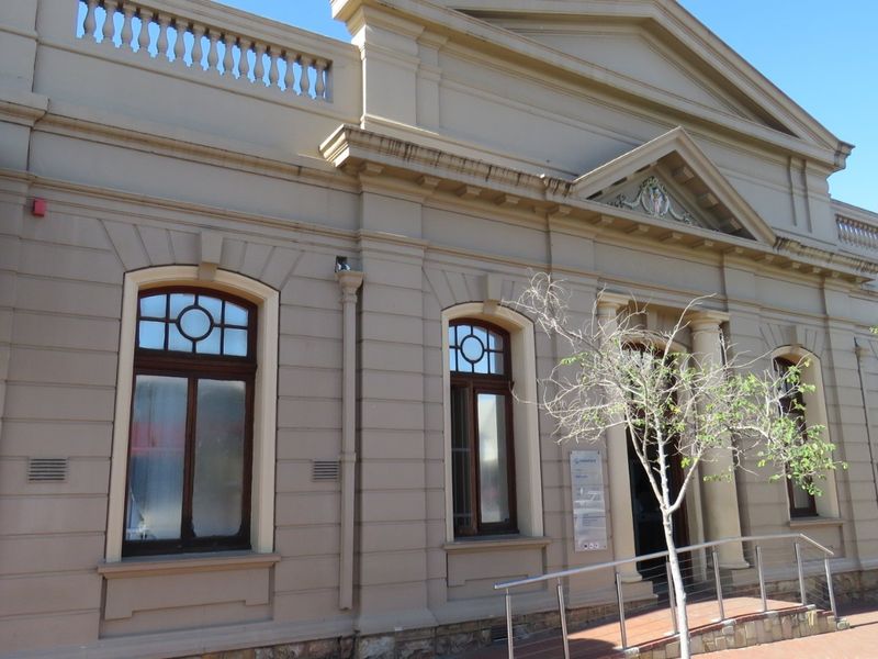 A well-maintained classical commercial building facade featuring arched windows, stone base detailing, and architectural columns.