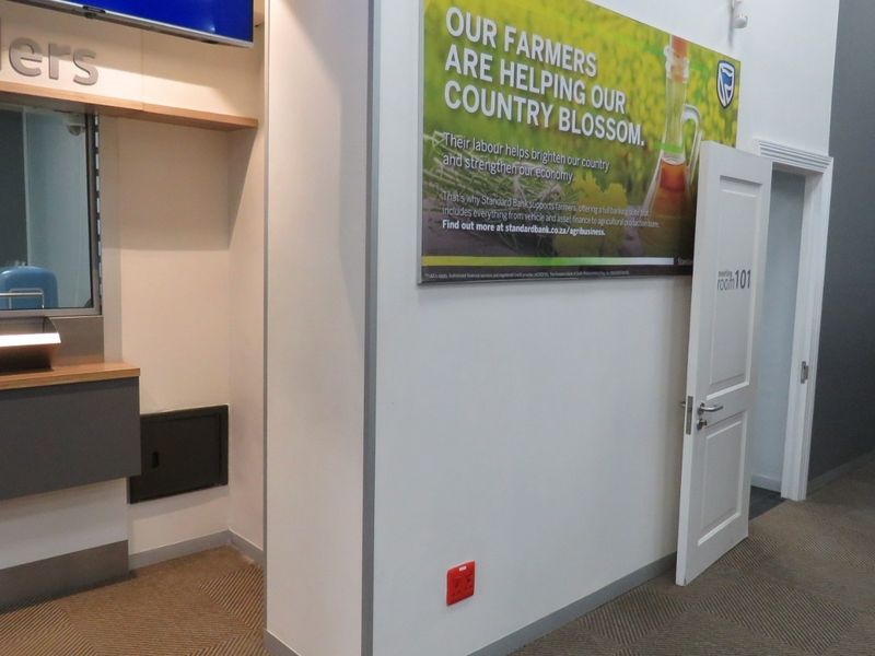 A professional office interior featuring a teller service counter, clean wall finishes, and access to a designated meeting room.