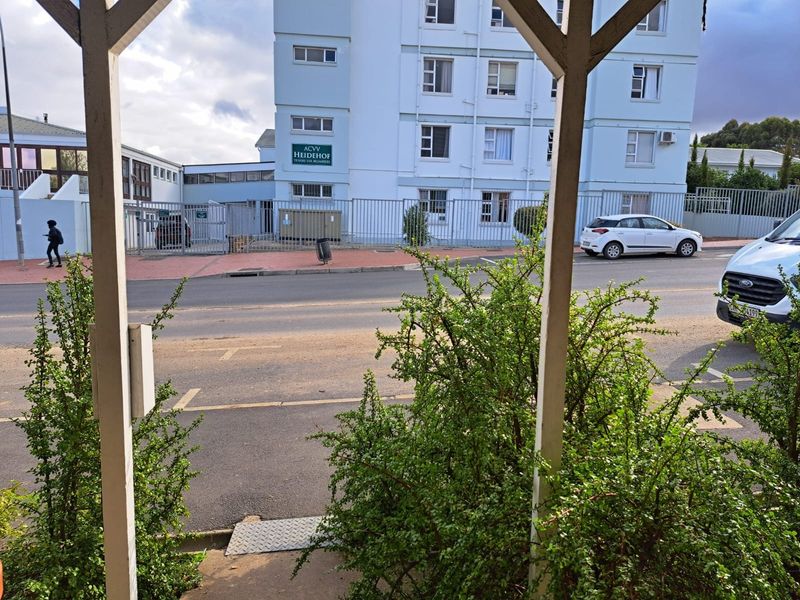 Street view showing the exterior facade of the ACVV Heidehof building, featuring secure perimeter fencing and a paved road approach.