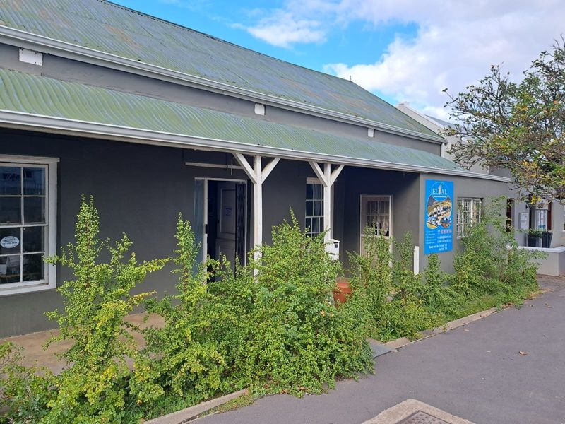 Front elevation of a commercial property featuring a covered veranda, corrugated iron roof, and traditional sash windows.