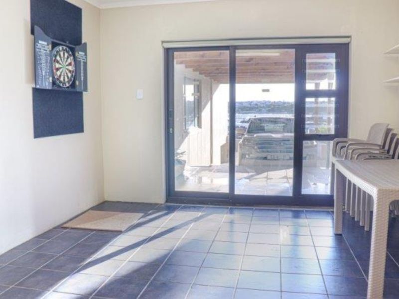 A functional living area featuring tiled flooring and a large sliding glass door providing access to an outdoor patio space.