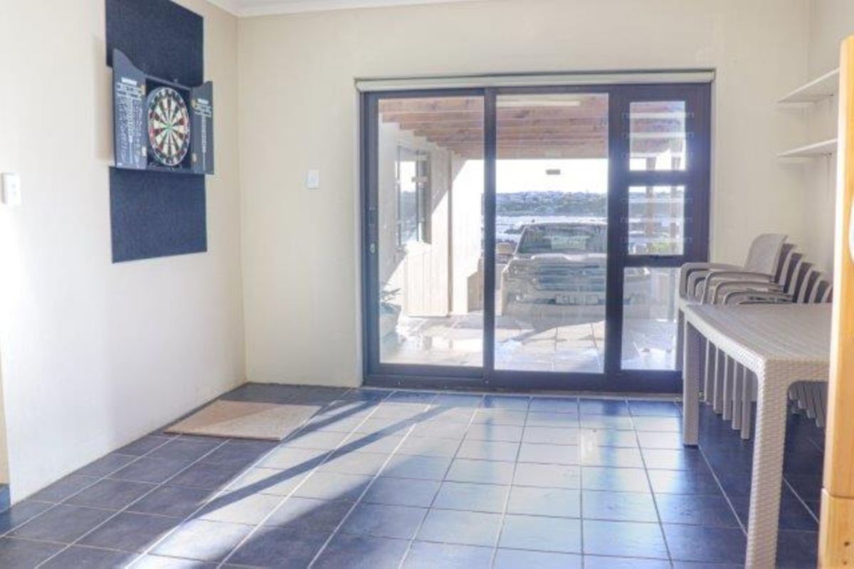 A functional living area featuring tiled flooring and a large sliding glass door providing access to an outdoor patio space.