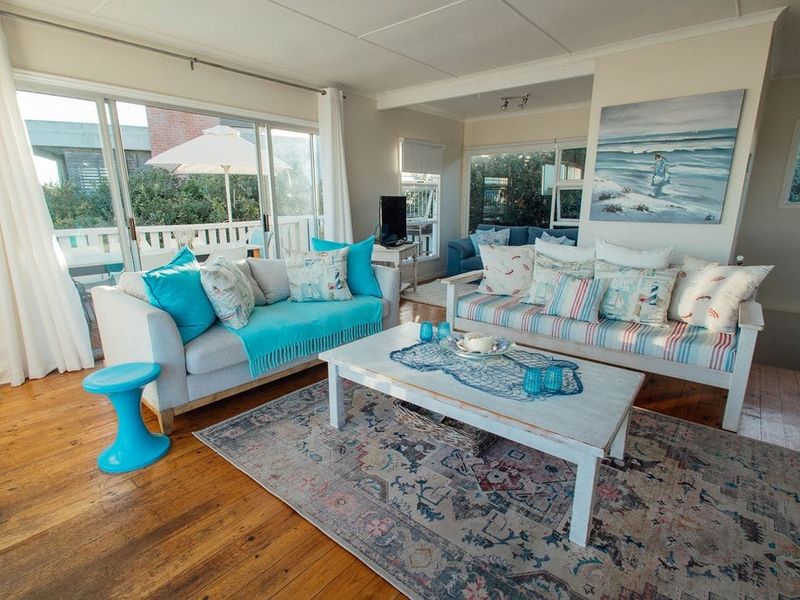 Bright living room featuring hardwood flooring and large sliding glass doors that provide ample natural light and access to the outdoor area.