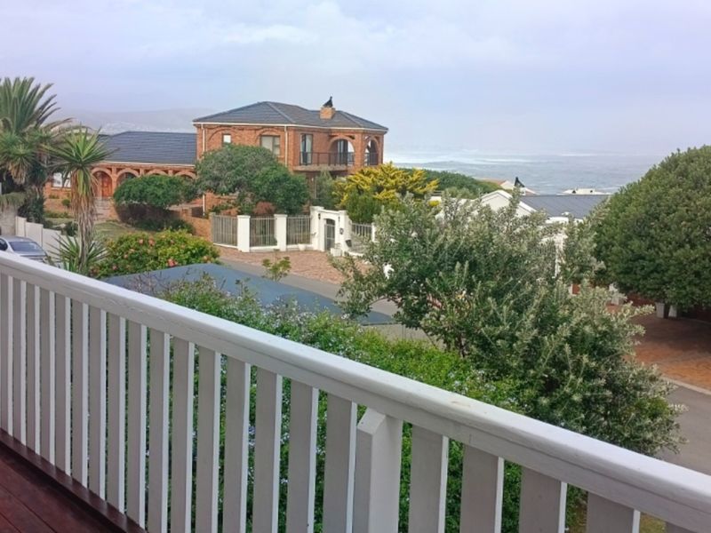 Elevated view from a timber deck overlooking the surrounding coastal neighbourhood and ocean horizon.