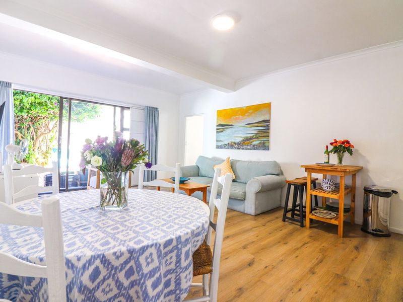 Bright open-plan living and dining area featuring laminate flooring and large sliding glass doors providing access to the outdoor space.