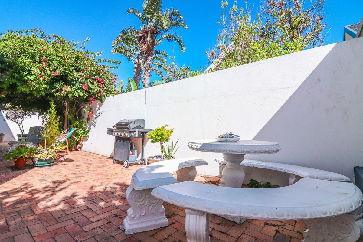 A private rear courtyard featuring brick paving and a high boundary wall, providing a secluded outdoor space.