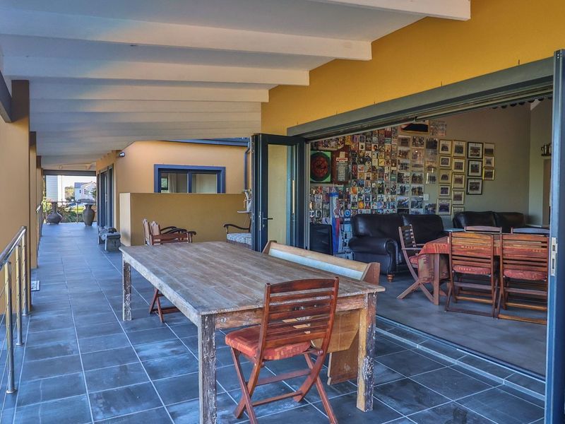 Spacious covered patio featuring tiled flooring and modern stacking glass doors that provide seamless indoor-outdoor flow to the living area.