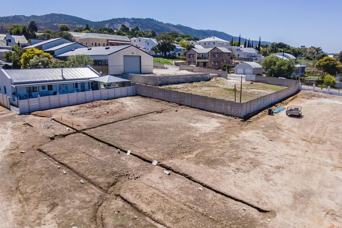 Aerial view of a vacant residential plot featuring cleared land and established precast concrete boundary walls in a suburban setting.