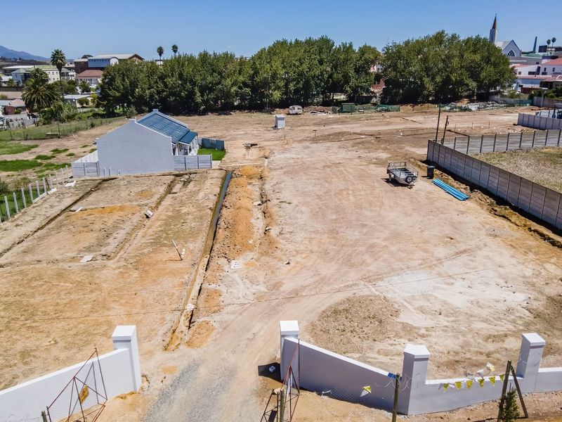 Aerial view of a large, cleared residential vacant land plot featuring perimeter walling and established boundary fencing in a suburban setting.