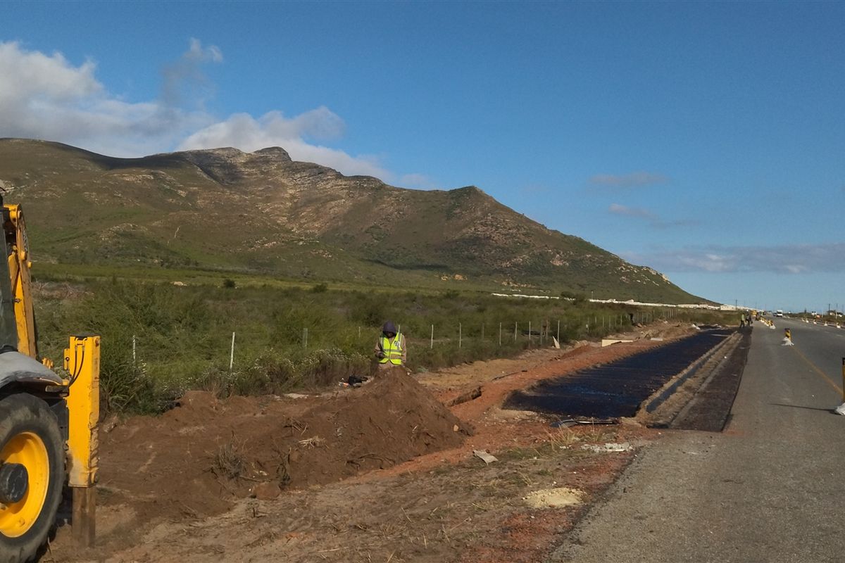 View of commercial land frontage showing ongoing road infrastructure development and roadside drainage works alongside the main thoroughfare.