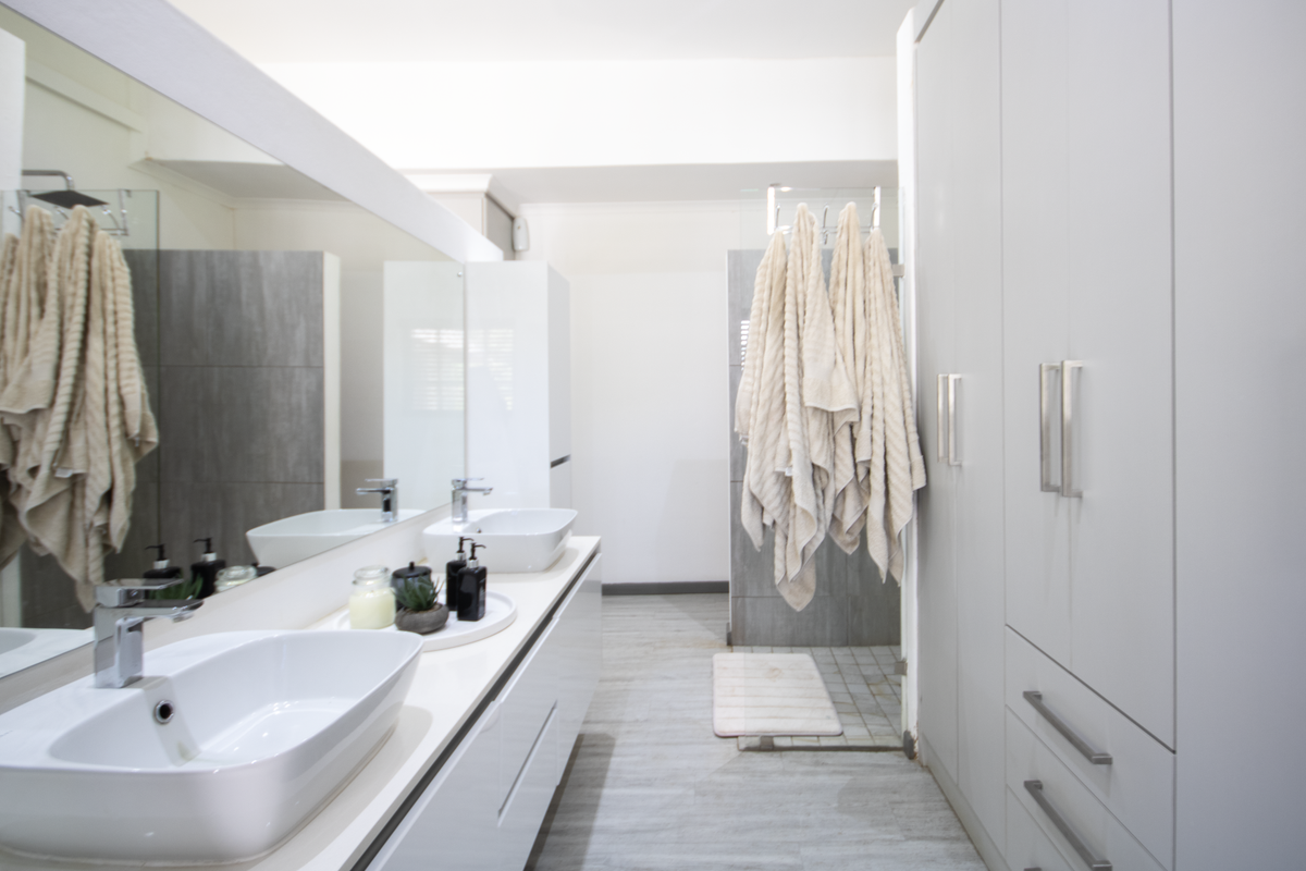 Modern bathroom featuring a double vanity with vessel sinks, large wall-mounted mirror, and built-in cabinetry for ample storage.