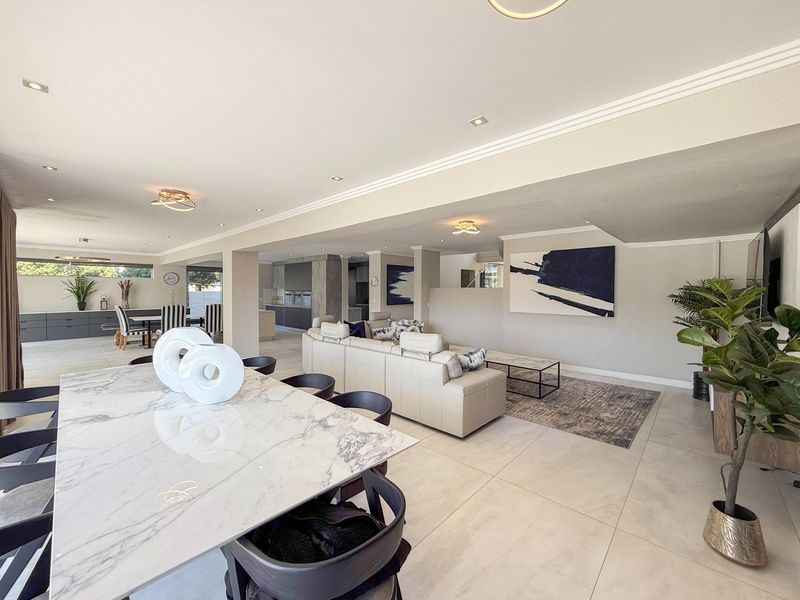 Spacious open-plan living area featuring large format floor tiles, recessed lighting, and a modern integrated kitchen with sleek cabinetry.