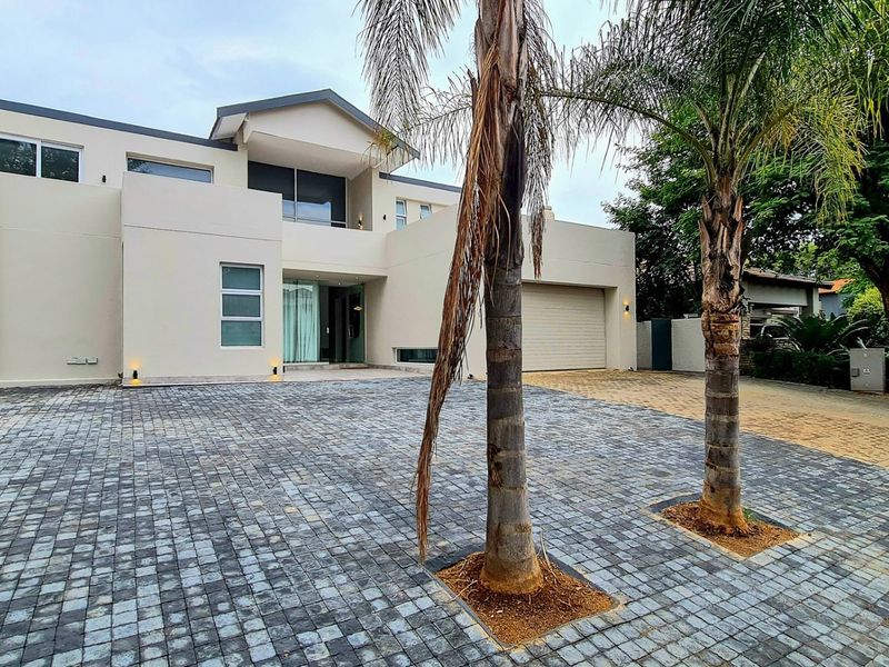 Modern double-story residential property featuring a paved driveway, integrated double garage, and contemporary architectural design.