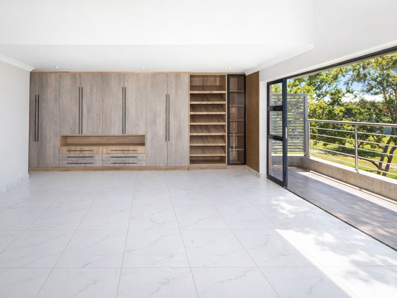 Spacious living area featuring modern built-in cabinetry, marble-look floor tiles, and large sliding glass doors opening onto a private balcony.