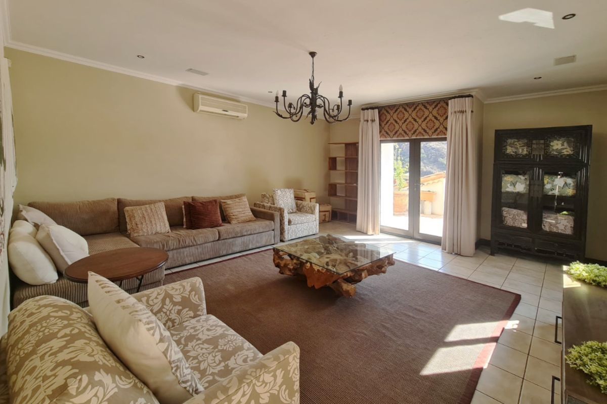 Spacious living room featuring tiled flooring, a split-system air conditioner, and direct access to an outdoor patio area through sliding glass doors.