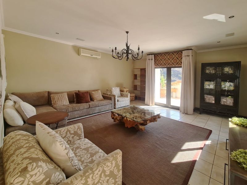 Spacious living room featuring tiled flooring, a split-system air conditioner, and direct access to an outdoor patio area through sliding glass doors.