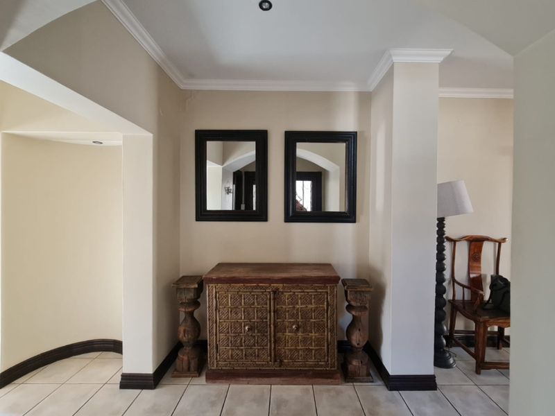A welcoming entry area featuring neutral wall tones, tiled flooring, and decorative crown molding, providing a clean transition between living spaces.
