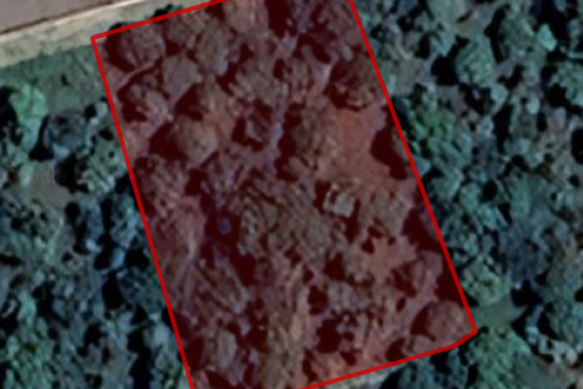 An aerial view showing the boundary of a vacant residential land plot.