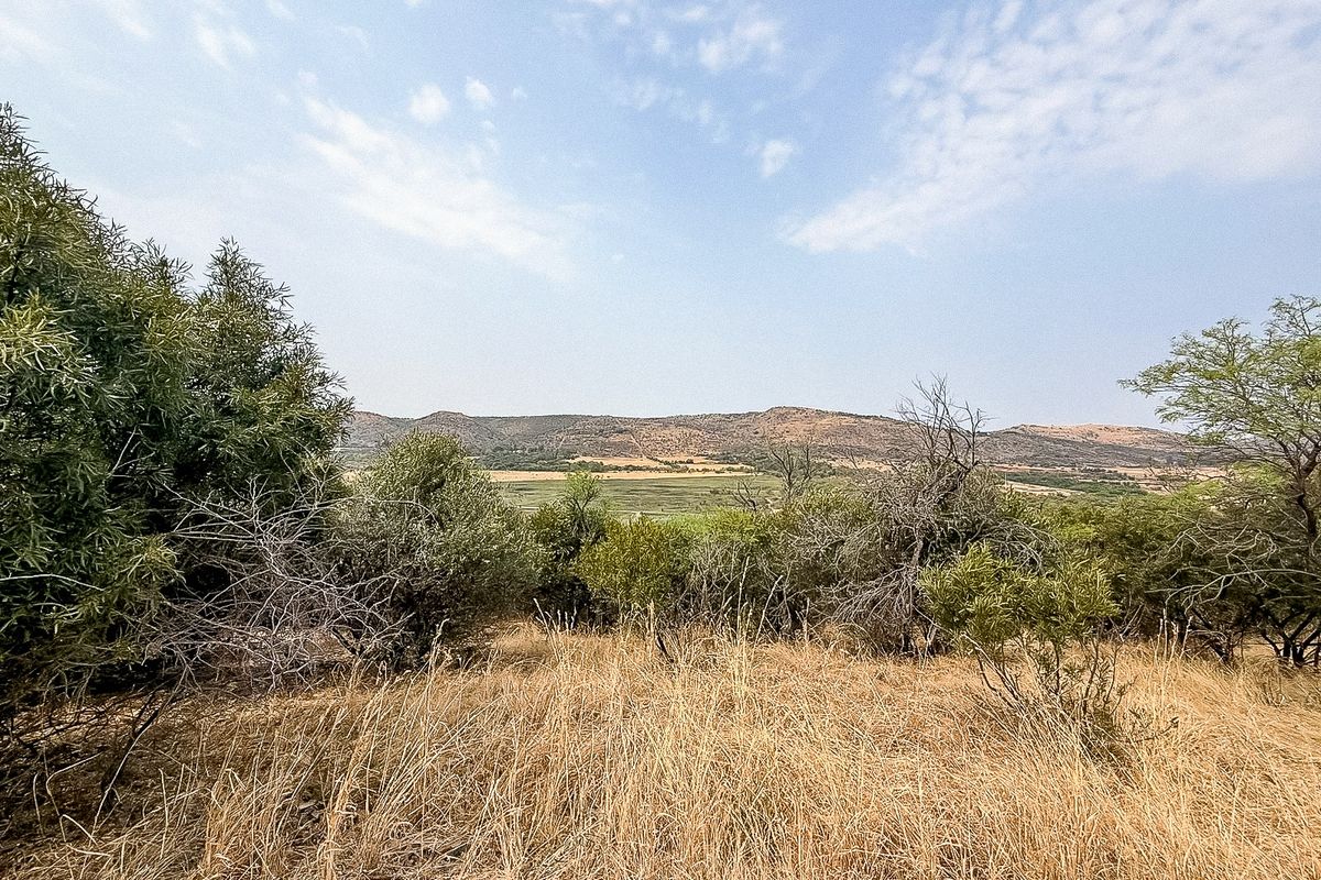 A scenic view of the surrounding landscape, featuring natural vegetation and distant hills, showcasing the property's rural setting.