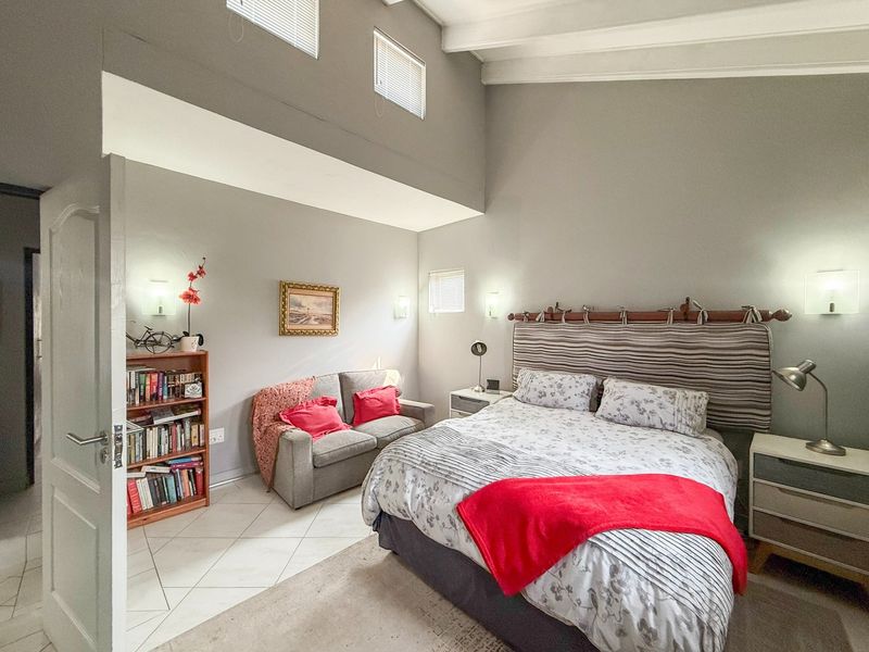 Spacious bedroom featuring high vaulted ceilings, tiled flooring, and clerestory windows that provide ample natural light.