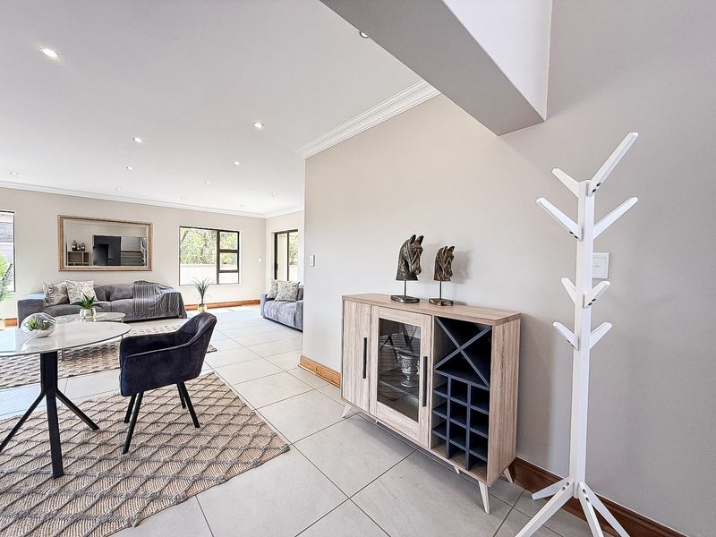Spacious open-plan living area featuring neutral tiled flooring, recessed downlighting, and clean architectural finishes throughout the bright, airy space.