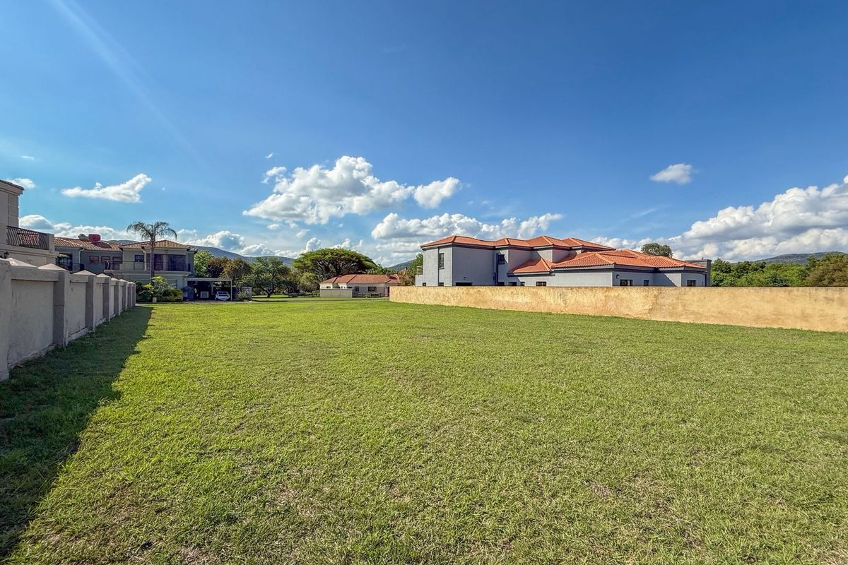A spacious, well-maintained vacant residential plot featuring a level lawn and established boundary walls in a quiet neighborhood setting.