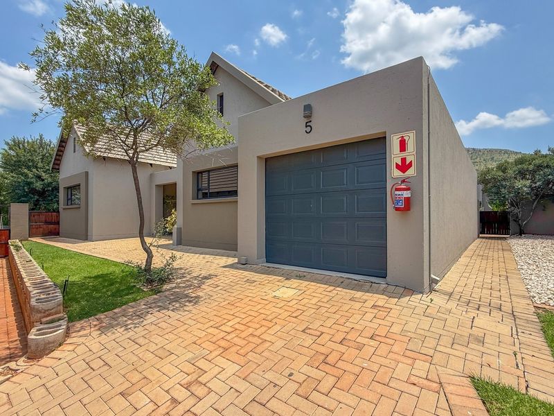 Front exterior view of a townhouse featuring a paved driveway, single garage, and well-maintained facade.