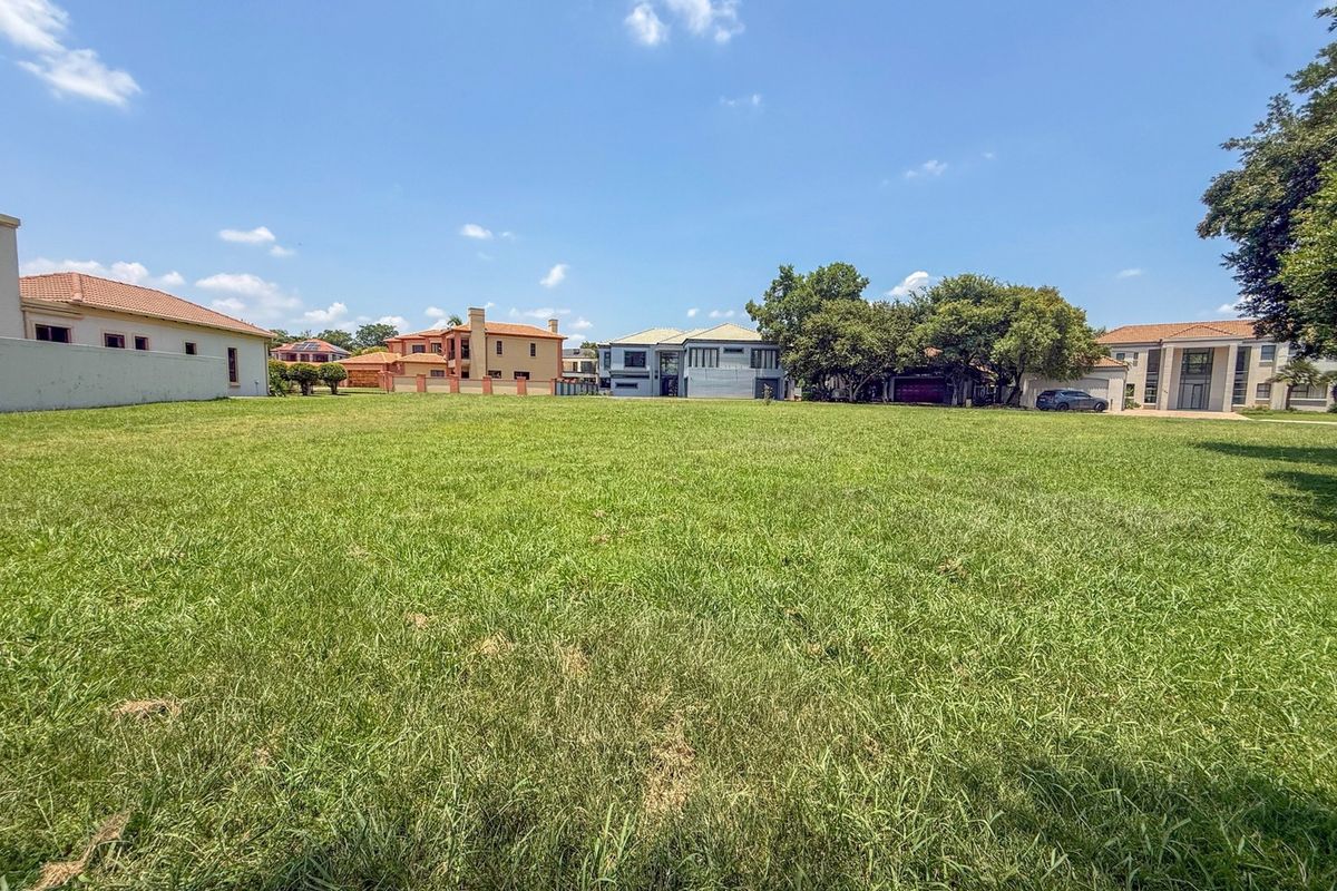 A spacious, level residential vacant land plot featuring a well-maintained grass lawn and established boundary walls in a developed neighborhood.