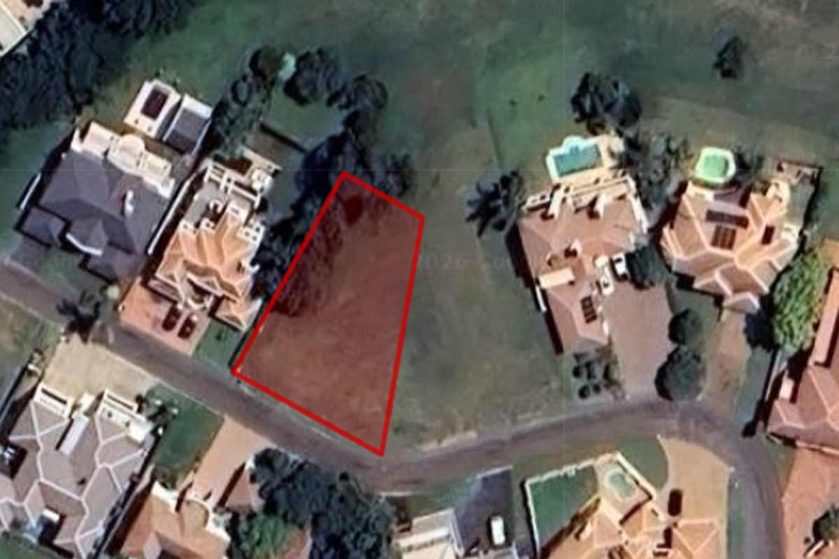 Aerial view of a vacant residential land plot situated within an established neighborhood.