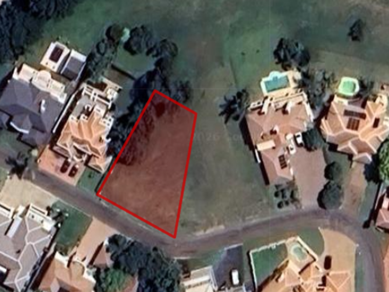 Aerial view of a vacant residential land plot situated within an established neighborhood.
