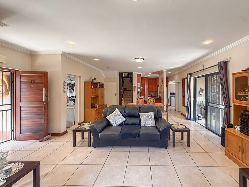 Spacious open-plan living area featuring tiled floors, recessed lighting, and direct access to the exterior through sliding glass doors.