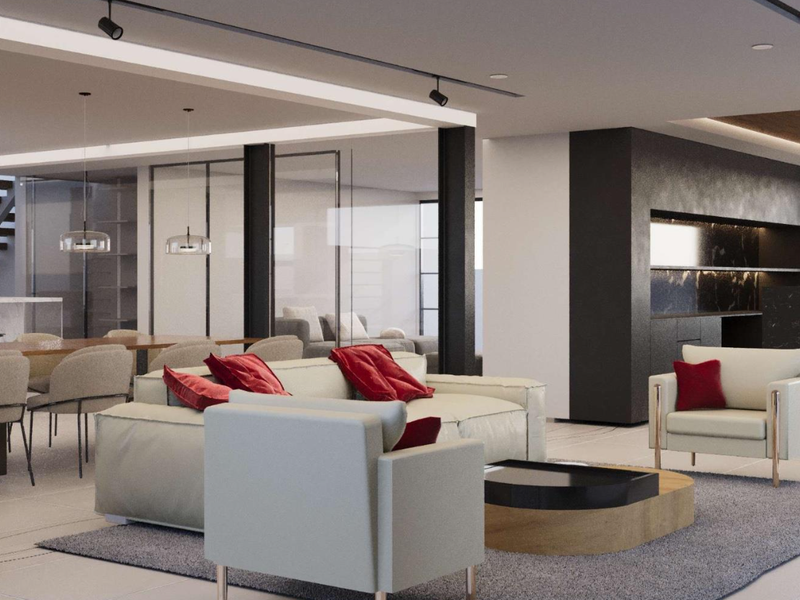 Modern open-plan living area featuring a sleek kitchen with marble island, contemporary track lighting, and glass-partitioned spaces with a central staircase.