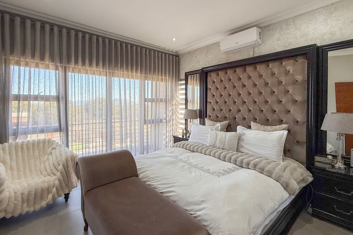 A well-maintained bedroom featuring tiled flooring, a split-system air conditioner, and large sliding glass doors that provide ample natural light.