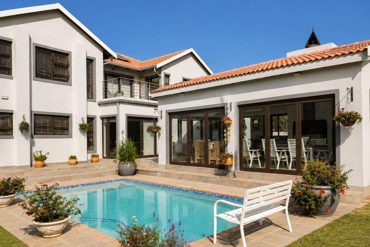 A well-maintained rear exterior view featuring a swimming pool, paved patio area, and modern house architecture with large sliding glass doors.