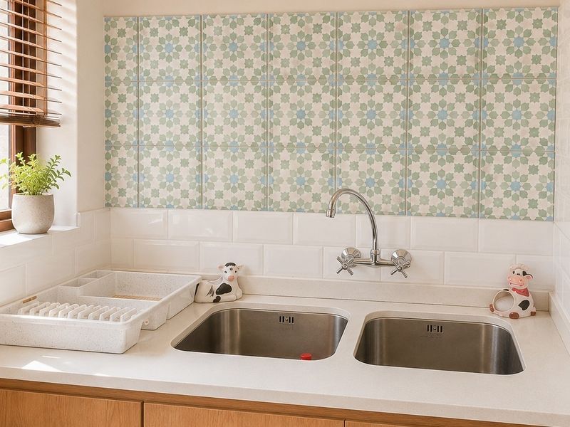 A well-maintained kitchen area featuring a double stainless steel sink, stone countertops, and a decorative tiled backsplash with wooden cabinetry.