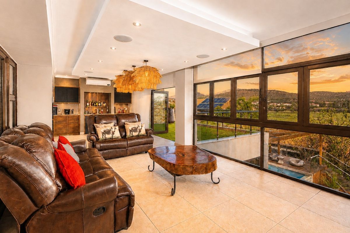 Spacious living room featuring large floor-to-ceiling windows with scenic views, built-in bar cabinetry, recessed ceiling lighting, and tiled flooring.