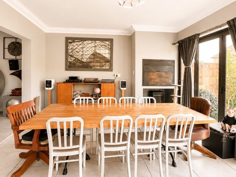 Spacious dining room featuring tiled flooring, crown molding, and a built-in fireplace, with direct access to the outdoor area through sliding glass doors.